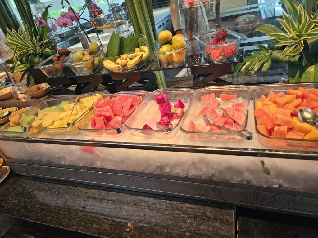아야나 에스테이트 조식 뷔페의 신선한 과일 코너입니다. 잘라 놓은 수박, 파파야, 용과 등 열대과일과 통과일이 얼음 위에 보기 좋게 진열되어 있습니다.