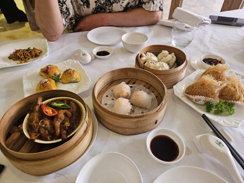 발리 아야나 리조트에서 즐기는 딤섬 점심 식탁. 찜통에 담긴 닭발, 만두, 그리고 튀김 요리 등 다양한 딤섬이 푸짐하게 차려져 있다.