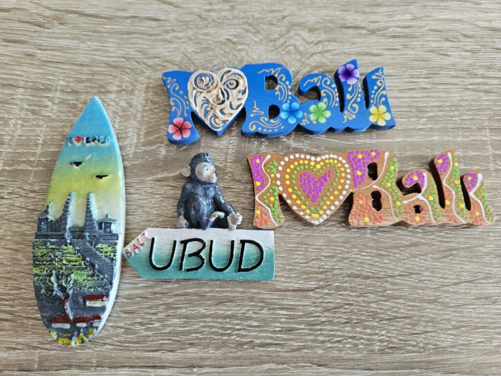 발리 신혼여행 기념품으로 모아둔 I LOVE BALI 마그넷, 우붓 표지판 원숭이 모형, 서핑보드 모양의 발리 풍경 장식.