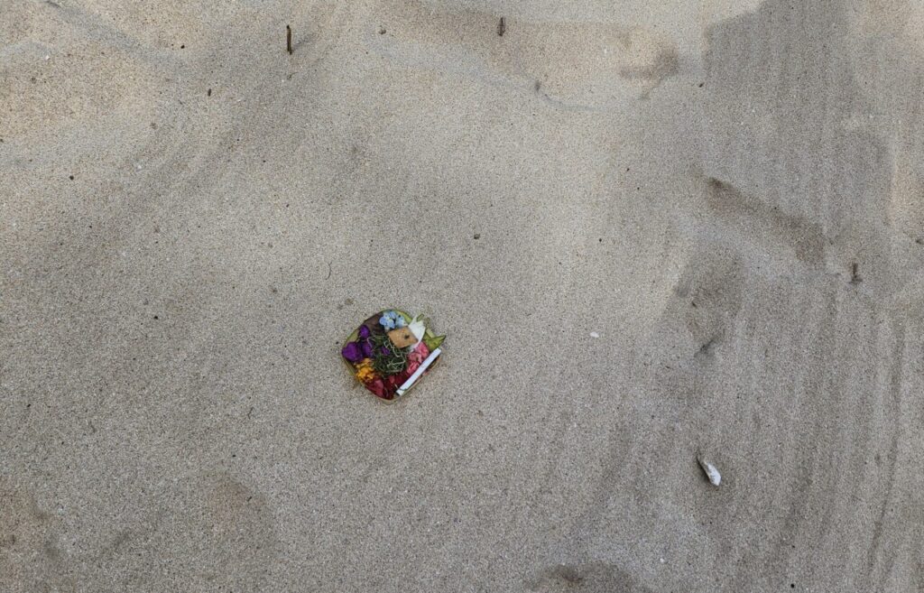 발리 쿠부 비치 모래사장 위에 놓인 작고 색색깔의 전통 발리 제물(짜낭 사리).