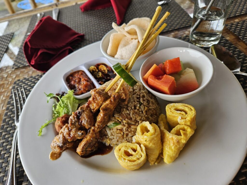 발리 현지 식당에서 맛본 나시고랭 스페셜. 사테 꼬치, 계란말이, 신선한 과일, 크루푹, 삼발 소스가 함께 제공된 풍성한 인도네시아식 한 끼 식사.