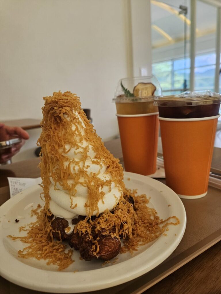 바삭한 브라운 치즈가 듬뿍 뿌려진 크로플 위의 부드러운 상하목장 아이스크림 디저트.