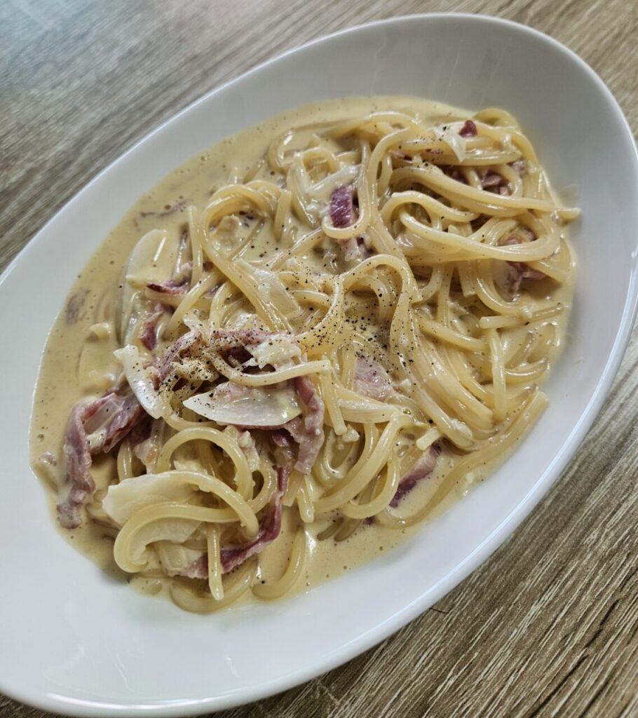 하얀 접시에 담긴 베이컨 크림 파스타