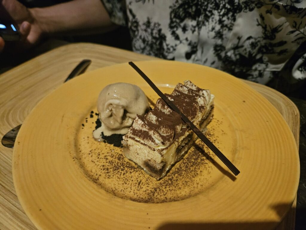 노란색 접시에 담긴 티라미수와 아이스크림