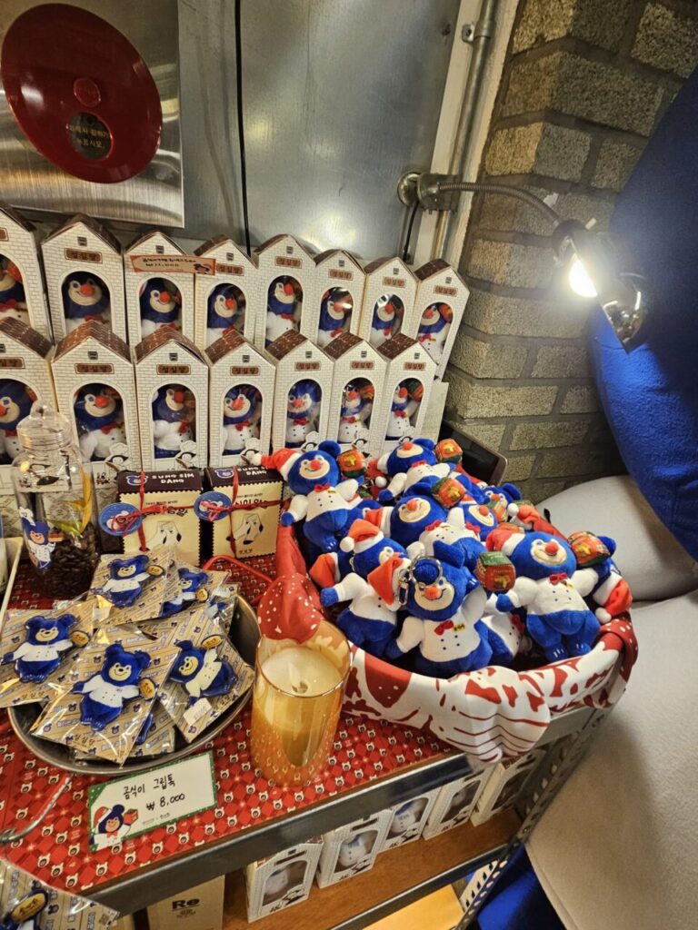 대전 성심당에서 판매하는 파란색과 흰색 스노우맨 캐릭터 인형들. 선물용 상자에 담겨 있거나 바구니에 쌓여 있다.