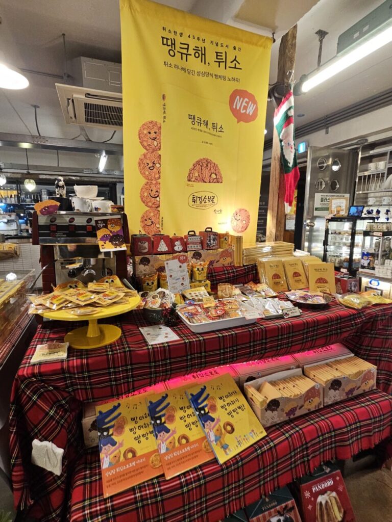 대전 성심당 튀소 출시 45주년 기념 '땡큐해, 튀소' 프로모션 진열대. 다양한 튀소 관련 제품과 굿즈가 전시되어 있다.
