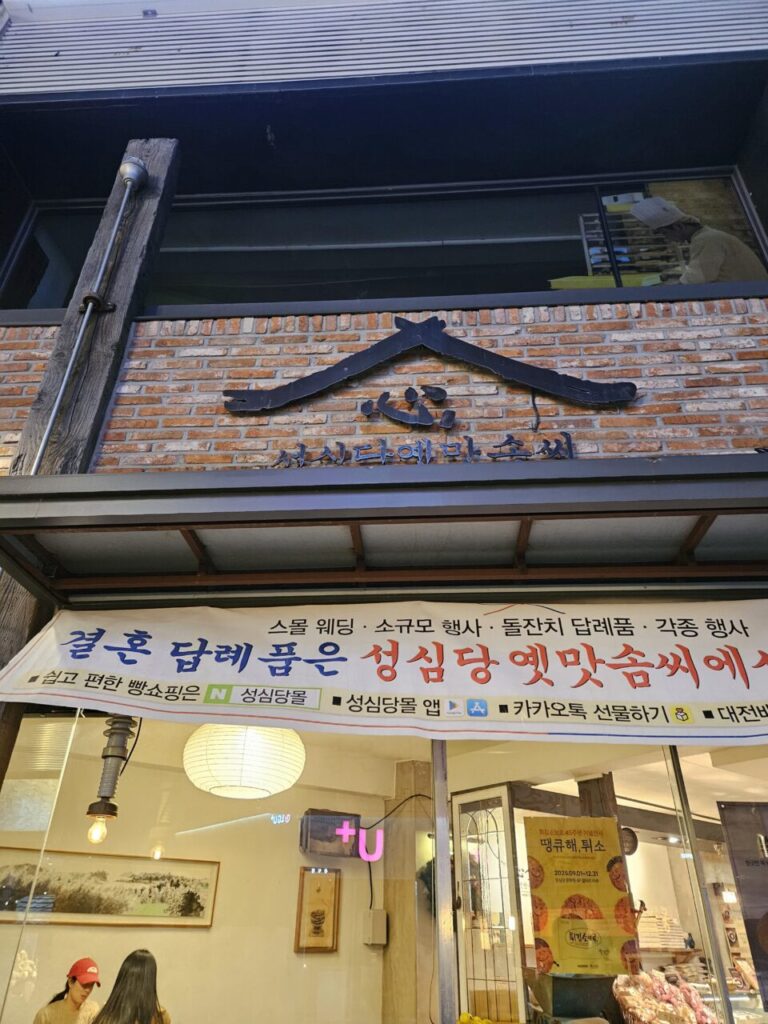 대전 성심당 옛맛솜씨 건물의 외부 전경. 벽돌 건물에 한글 상호가 크게 걸려 있고, 결혼 답례품 등 홍보 배너가 보인다.